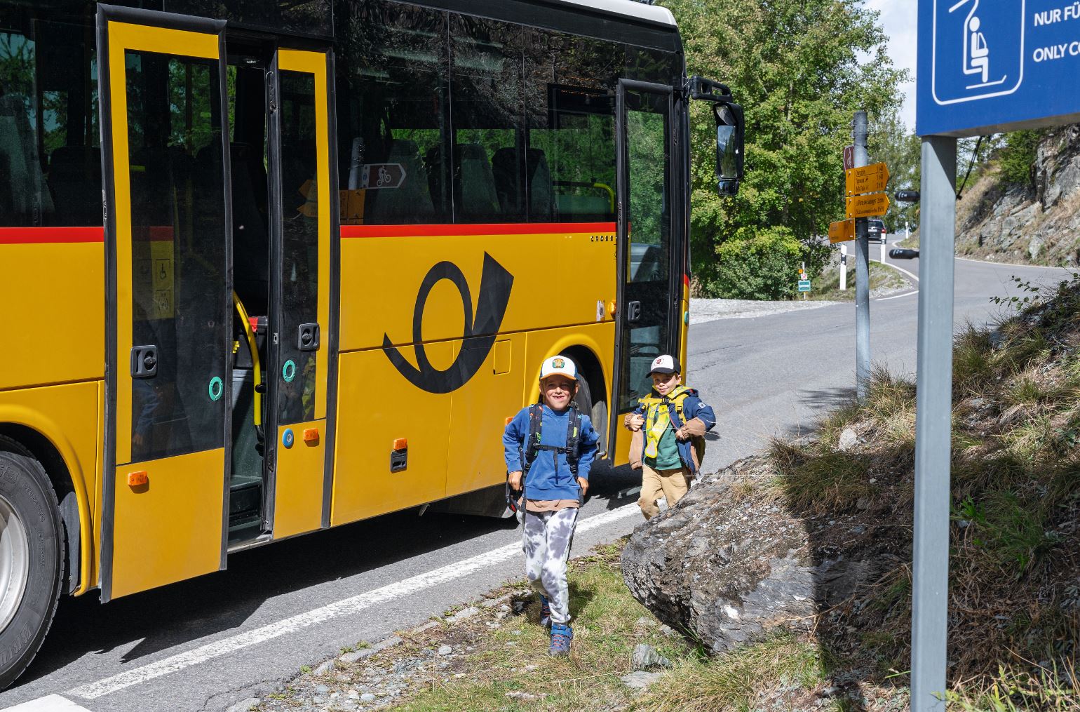 Für Theo und Luis gehts mit dem Postauto in die Schule.