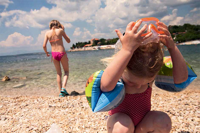 Zwei Mädchen spielen am Kieselstrand