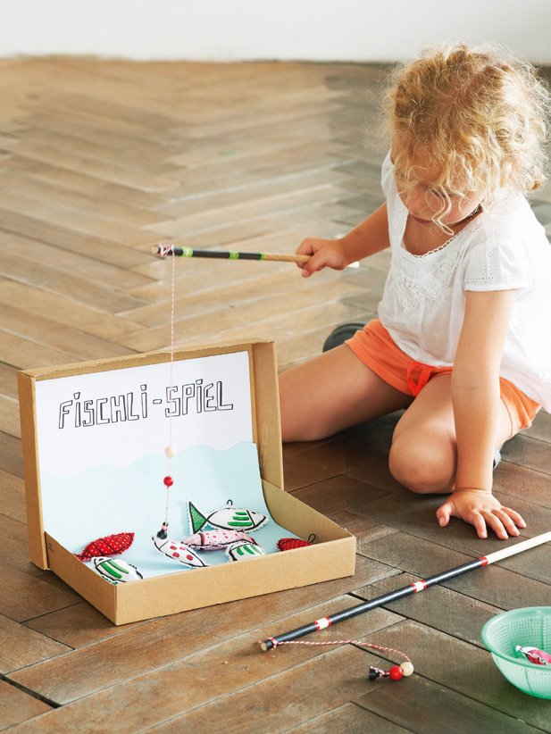 Kind angelt im Kartonschachtel-Teich