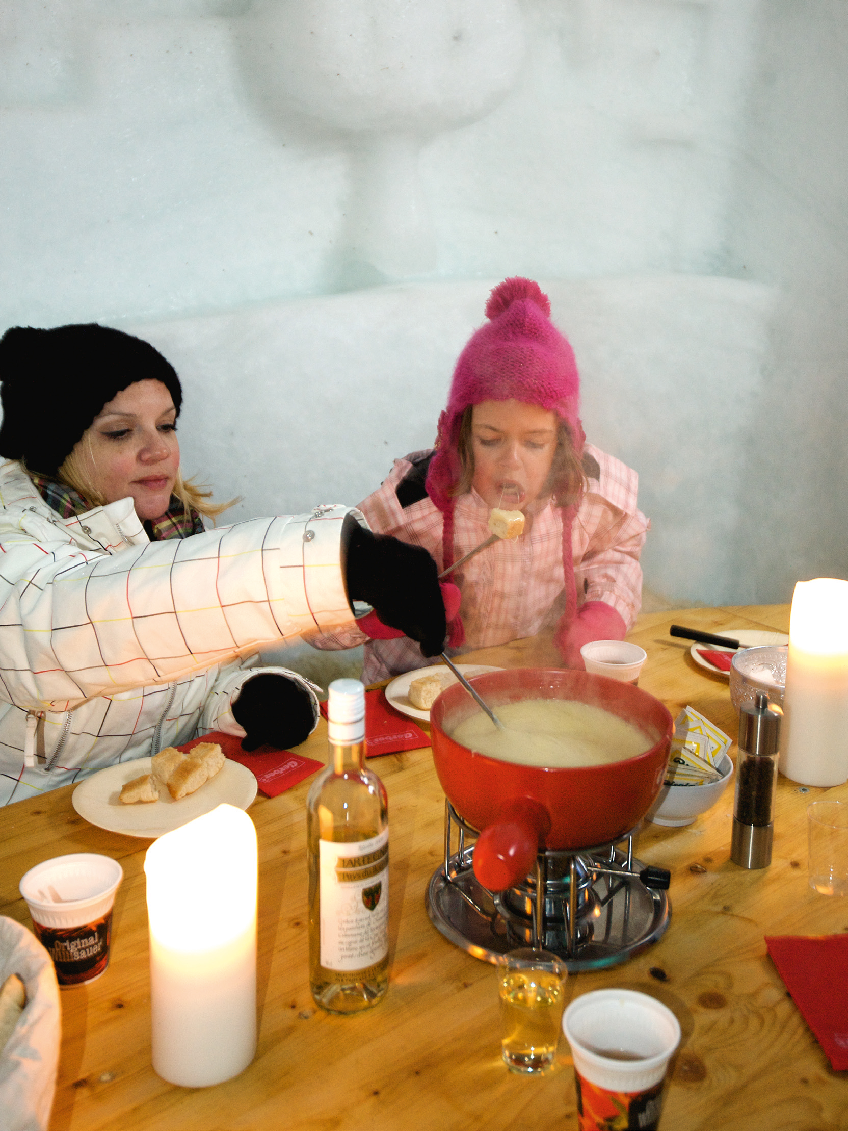 Mutter und Tochter beim Fondue-Essen im Iglu