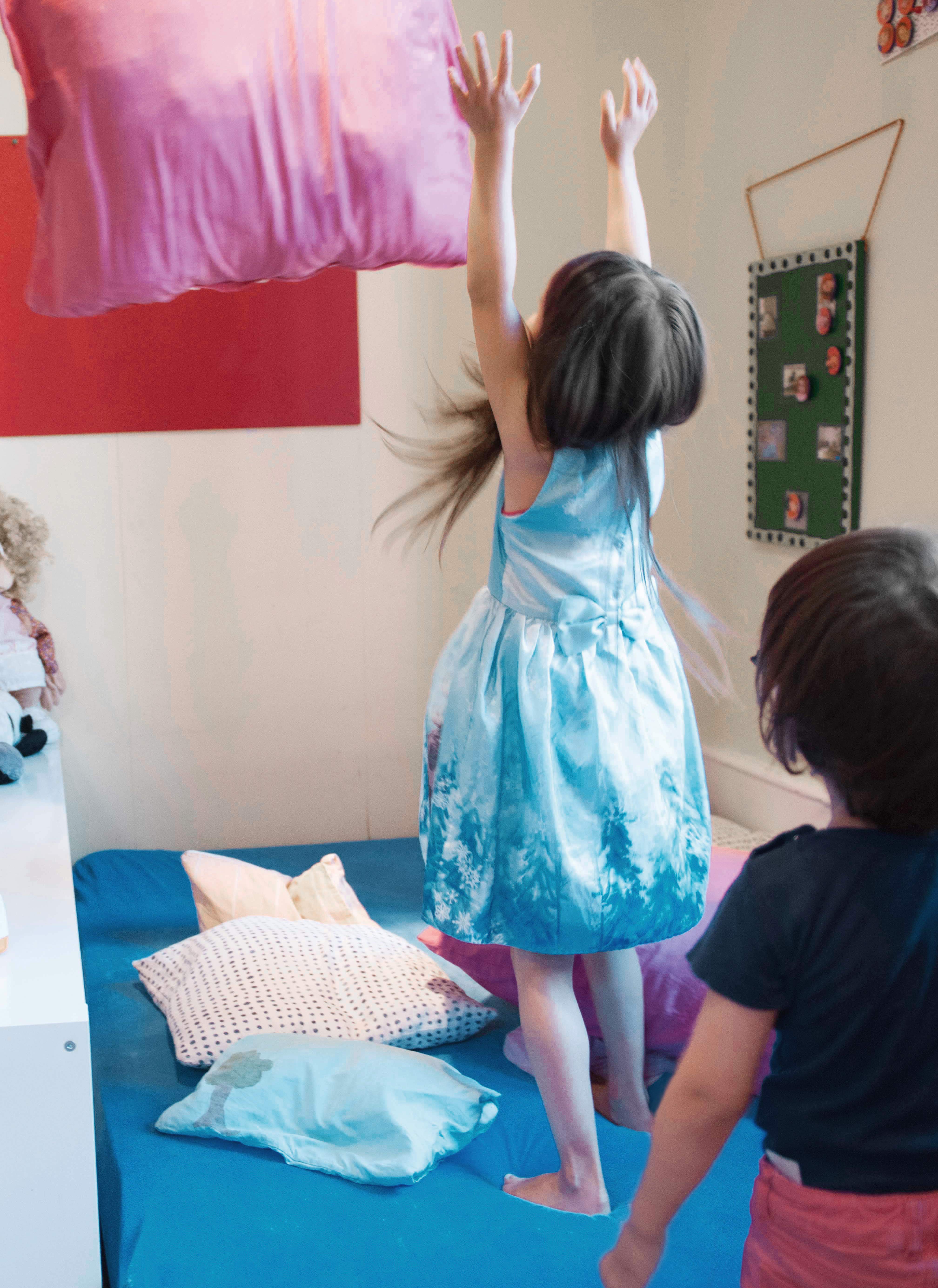 Zwei Kinder spielen auf einem Bett