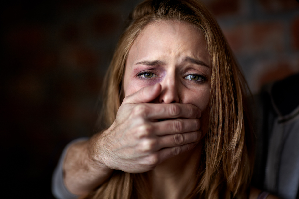 Mann hält einer Frau den Mund zu