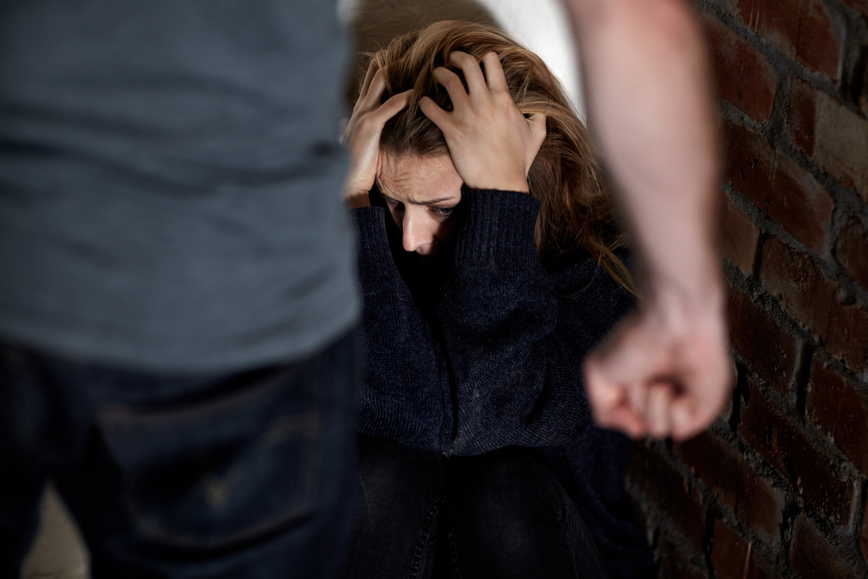 Mann mit Faust vor einer wehrlosen Frau