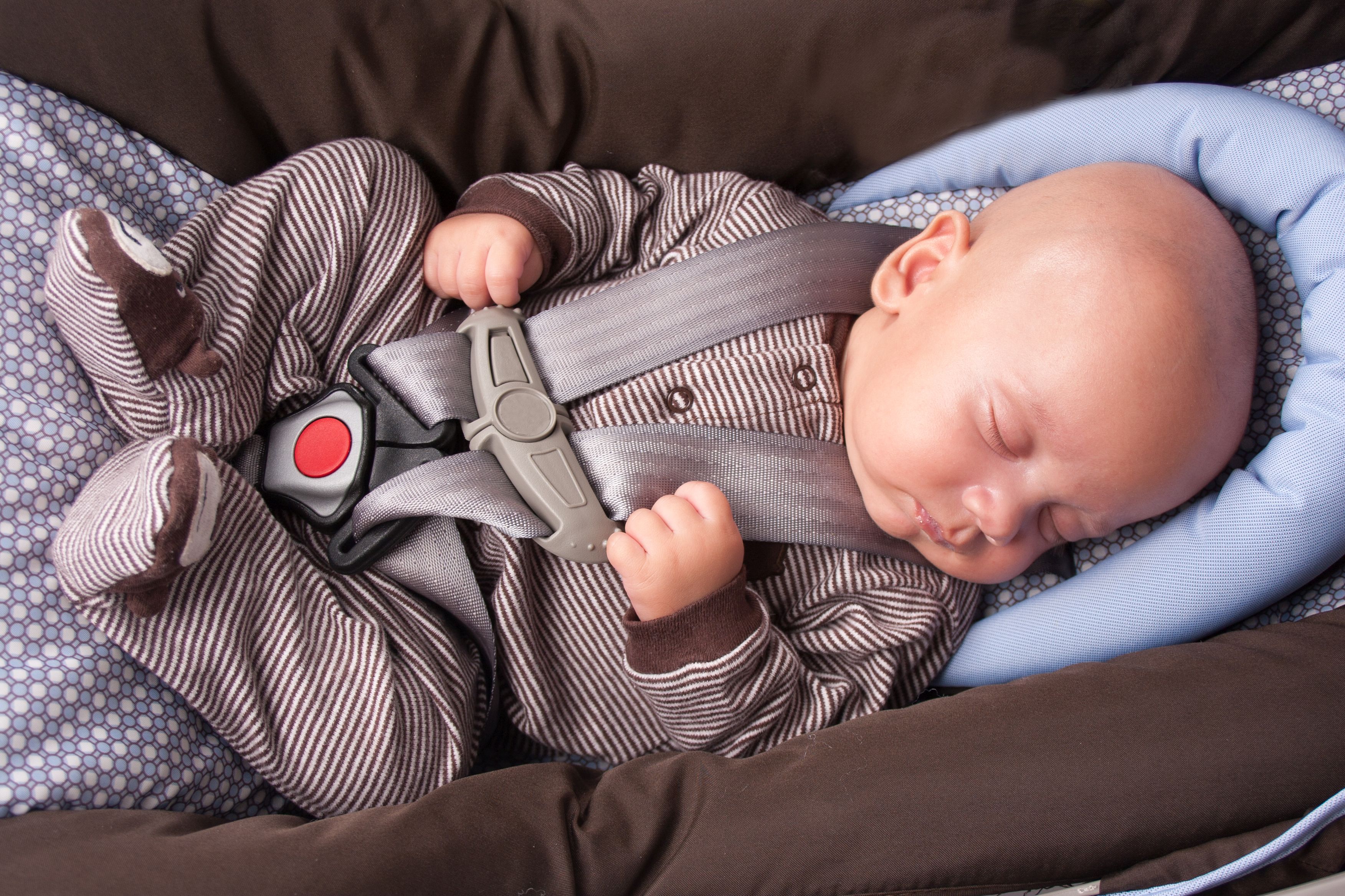 Ein Baby schläft in der Babyschale im Auto.